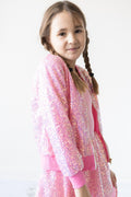 Child wearing a bubblegum-pink sequin jacket